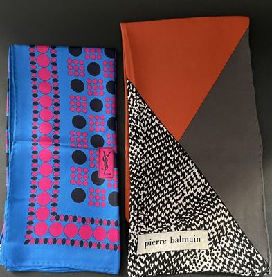 two different colored handkerchiefs on a table with a black background