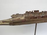 un petit bateau en bois posé sur un socle