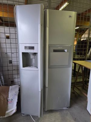 two refrigerators and a freezer in a warehouse