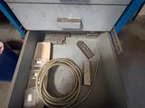 a metal drawer with a computer and a cable in it