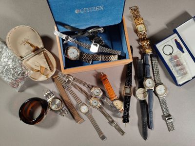 une boîte contenant des montres et d'autres objets qui se trouvent sur la table