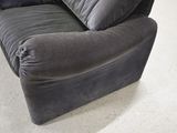 a grey couch with pillows on it in a room