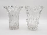une paire de vases en verre transparent posés sur une surface blanche