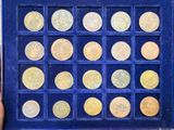 someone is holding a blue box with a lot of gold coins in it