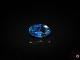 a close up of a blue sapphire stone on a black surface