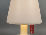 une lampe de table blanche sur laquelle est apposée une étiquette rouge