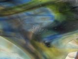 a close up of a glass vase with a blue and green design