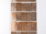quatre morceaux de bois sont empilés les uns sur les autres contre un mur blanc