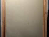 an image of a painting on a wooden easel in a dark room