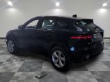 a black jaguar car parked in a garage with a checkered floor