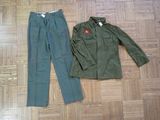 a green jacket and pants on the floor next to each other