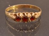 a gold ring with garnetts on it on a table