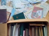 une boîte en carton remplie de livres et de papiers, posée par terre