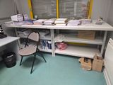 un bureau encombré de papiers et une chaise dans un coin