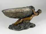 bronze sculpture of a woman holding a shell on a rock