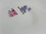 a white plate with pink and blue flowers on it
