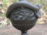 une statue représentant un serpent au sommet d'un vase
