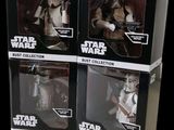 three star wars action figures sit in boxes on a black background