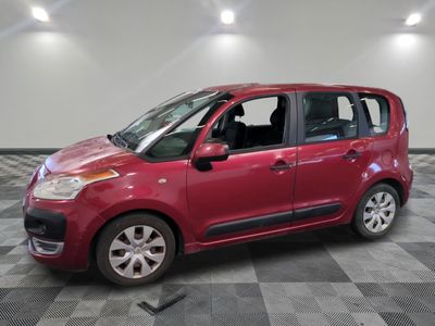 the small red car is parked on a checkered tile floor