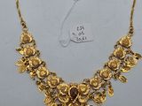 un collier en or orné de feuilles et de fleurs