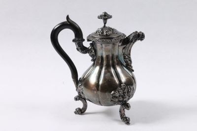 une cafetière en argent posée sur un support, sur un fond blanc