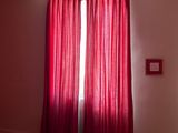 une chambre avec un lit et des rideaux rouges