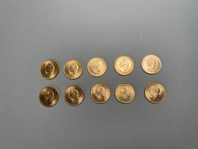 Plusieurs pièces d'or sont alignées sur une surface grise