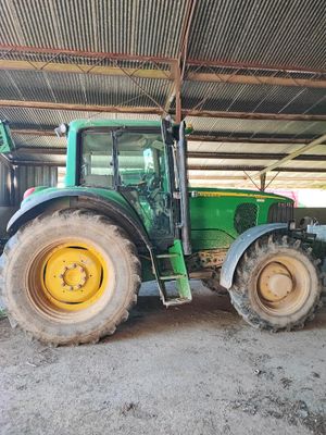 un tracteur vert garé dans une grange