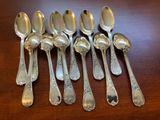 six silver spoons are lined up on a wooden table
