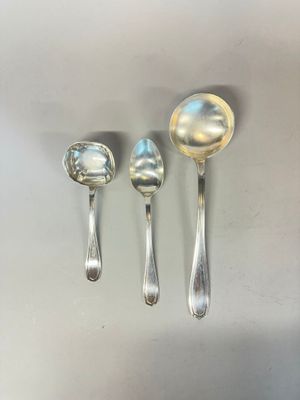 three silver spoons and a silver spoon on a white surface