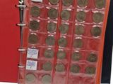 an image of a red binder with a bunch of coins in it