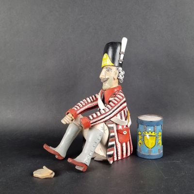 a figurine of a man sitting on a chair next to a can of beer