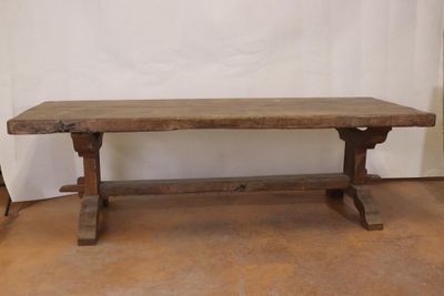 an old wooden table sitting on top of a hard wood floor