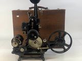 une machine à coudre à l'ancienne posée sur une table, à côté d'un morceau de bois