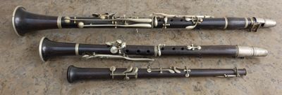 trois clarinettes sont alignées sur un plan de travail