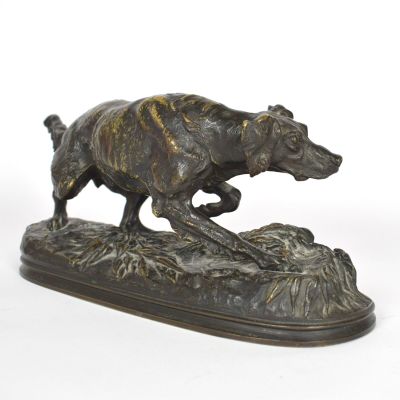 statue en bronze représentant un chien courant sur un rocher, sur fond blanc