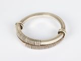 a close up of a silver bracelet on a white surface