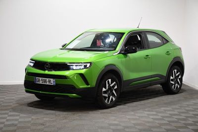 un SUV vert garé dans une pièce au sol carrelé