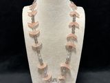 a close up of a necklace on a mannequin on a black background
