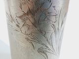 a silver vase with a design on it on a table