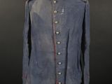 a blue military jacket with red trims and buttons on a mannequin stand