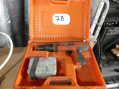 une mallette orange contenant des outils, posée sur une table