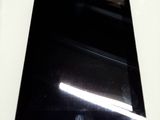 une tablette noire posée sur une table blanche