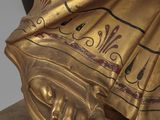 gold statue of a woman with an umbrella on a pedestal