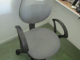 une chaise de bureau grise dans un coin d'une pièce