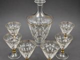 six glass wine glasses and a decanter on a table
