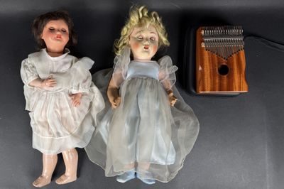 two dolls sitting next to each other on a table