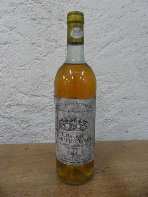 une bouteille d'alcool posée sur une table, avec un mur blanc en arrière-plan