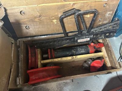 a wooden box with tools inside of it on the floor