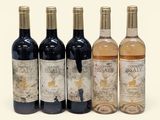 four bottles of wine sitting next to each other on a white surface